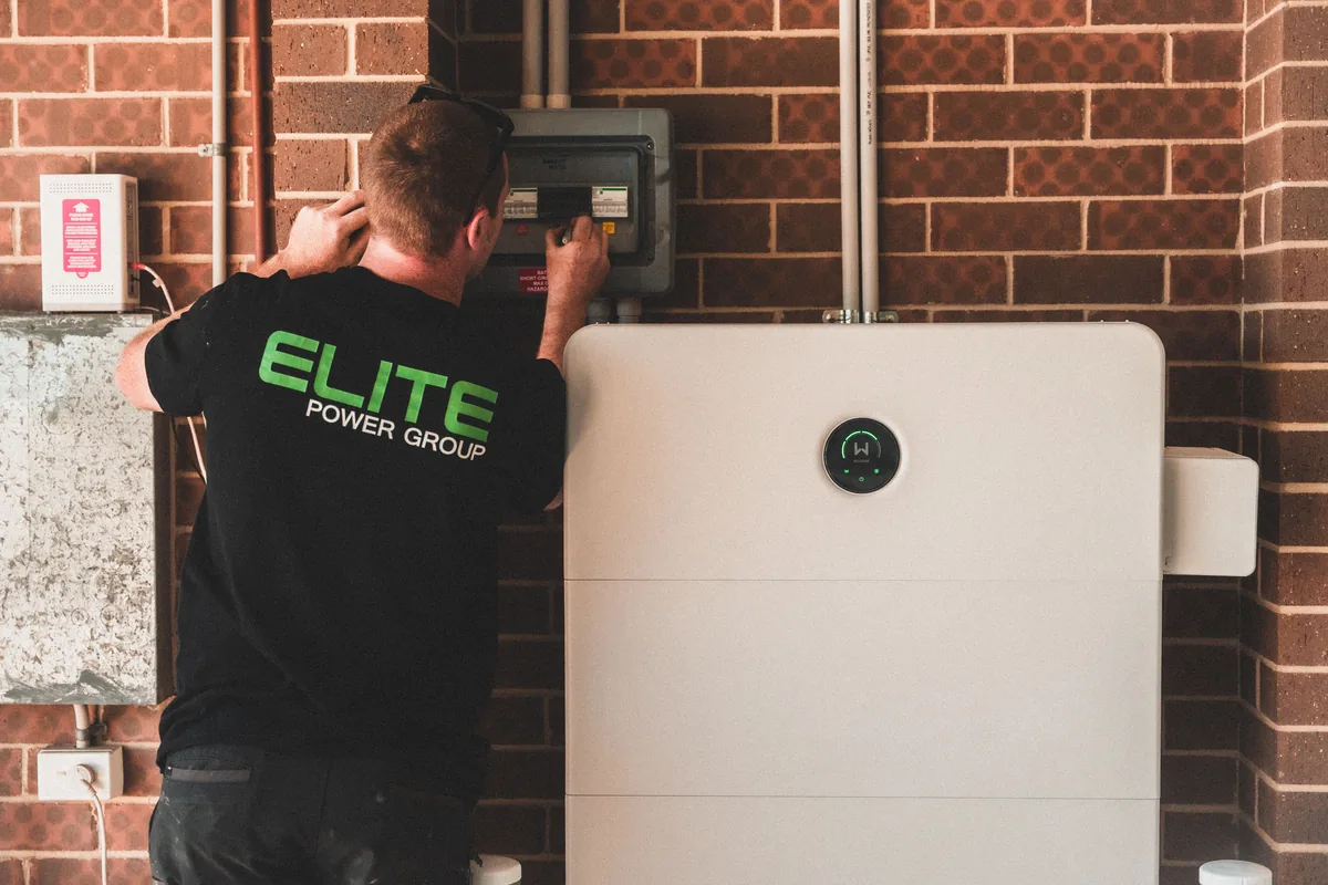 Wall-mounted home battery storage unit beside electrical equipment